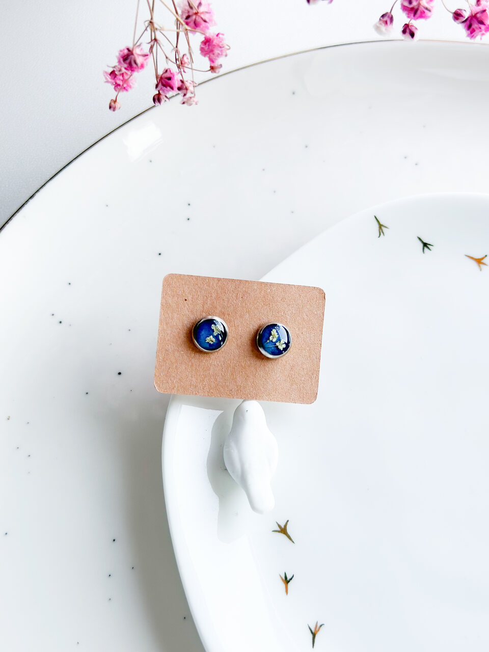 kolczyki z kwiatami, ręcznie robione kolczyki, biżuteria z żywicy, sztyfty z żywicy, kolczyki handmade, kolczyki z suszonymi kwiatami, kolczyki z żywicy epoksydowej, kolczyki z kwiatami marchwii, srebrne kolczyki z żywicy, ręcznie robione sztyfty, biżuteria z natury, kolczyki szafirowe tło, kolczyki z białymi kwiatami, delikatna biżuteria, romantyczne kolczyki, prezent dla niej, elegancka biżuteria, subtelna biżuteria, botaniczna biżuteria, kolczyki minimalistyczne, prezent handmade, prezent dla miłośniczki natury, małe kolczyki sztyfty, wyjątkowy prezent, biżuteria na prezent, kolczyki do codziennego noszenia, drobne kolczyki ręcznie robione