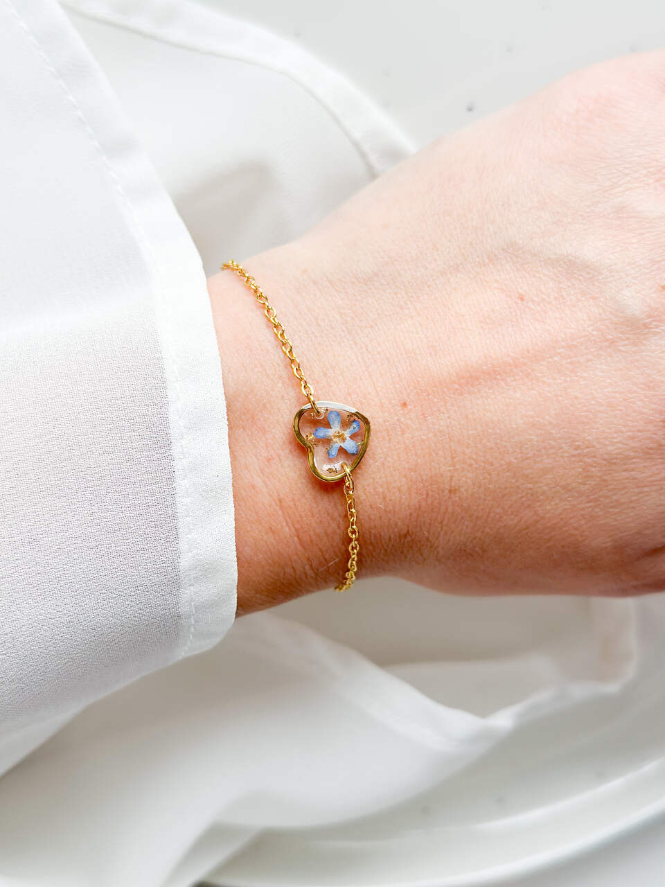 bransoletka z niezapominajką, bransoletka z żywicy, złota bransoletka damska, bransoletka z kwiatem w żywicy, biżuteria z żywicy, handmade biżuteria z kwiatami, delikatna bransoletka z serduszkiem, bransoletka z żywicy epoksydowej, naturalna biżuteria z kwiatów, bransoletka na prezent dla niej