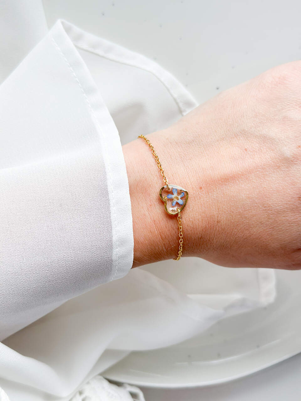 bransoletka z niezapominajką, bransoletka z żywicy, złota bransoletka damska, bransoletka z kwiatem w żywicy, biżuteria z żywicy, handmade biżuteria z kwiatami, delikatna bransoletka z serduszkiem, bransoletka z żywicy epoksydowej, naturalna biżuteria z kwiatów, bransoletka na prezent dla niej