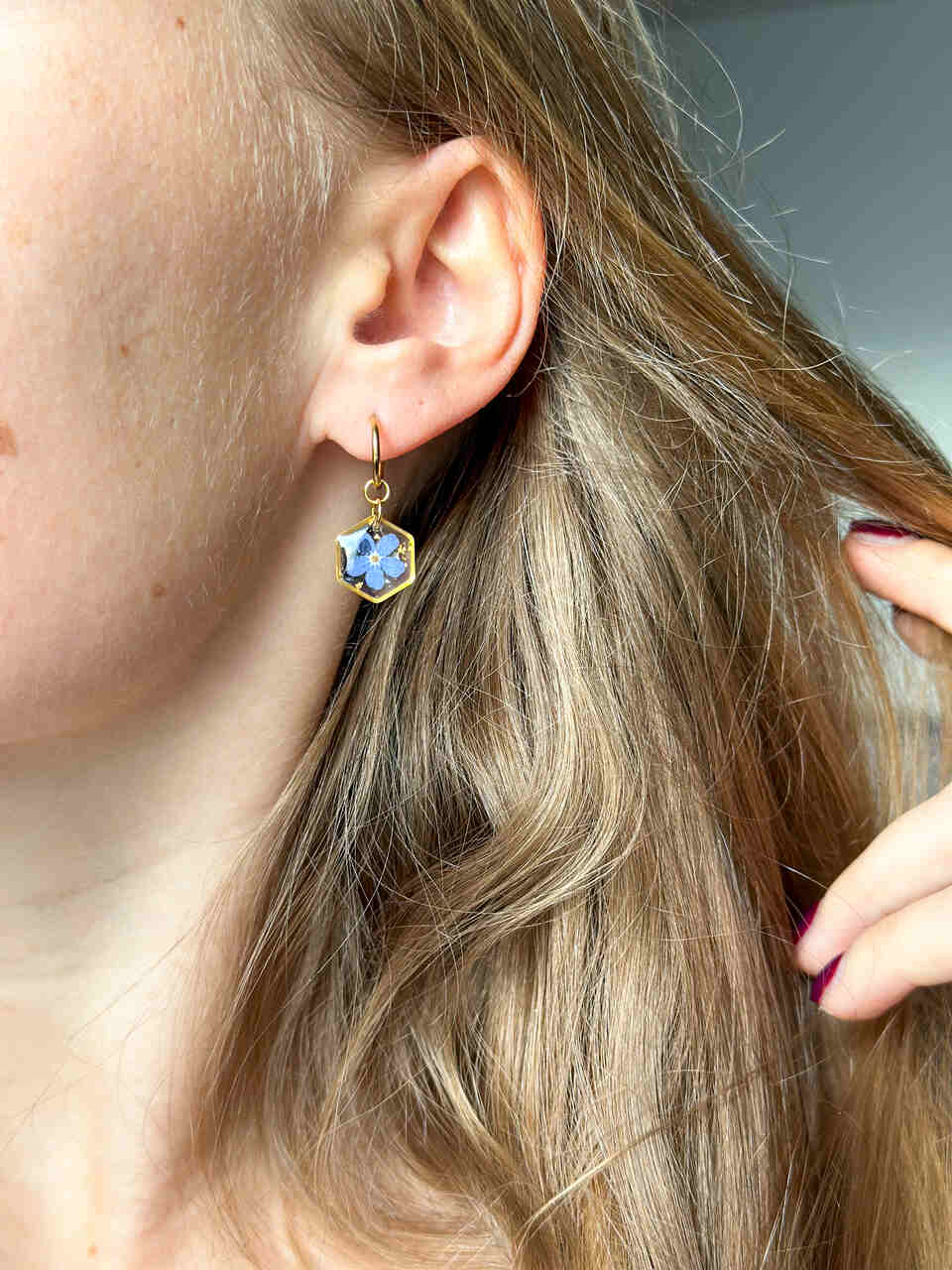 kolczyki z niezapominajką, złote kolczyki z żywicy, biżuteria z żywicy ręcznie robiona, kolczyki z kwiatami, kolczyki handmade, złote kolczyki z niezapominajką, biżuteria z prawdziwymi kwiatami, eleganckie kolczyki z żywicy