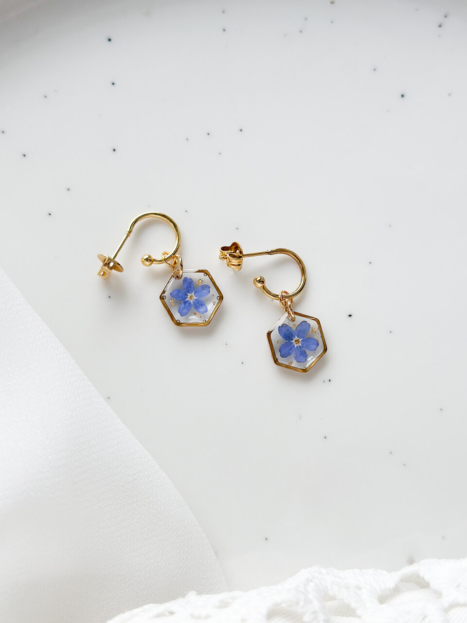 kolczyki z niezapominajką, złote kolczyki z żywicy, biżuteria z żywicy ręcznie robiona, kolczyki z kwiatami, kolczyki handmade, złote kolczyki z niezapominajką, biżuteria z prawdziwymi kwiatami, eleganckie kolczyki z żywicy
