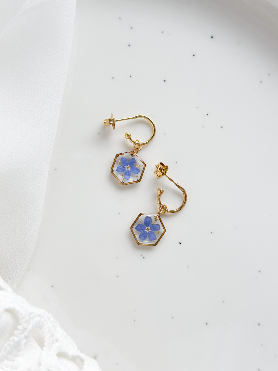 kolczyki z niezapominajką, złote kolczyki z żywicy, biżuteria z żywicy ręcznie robiona, kolczyki z kwiatami, kolczyki handmade, złote kolczyki z niezapominajką, biżuteria z prawdziwymi kwiatami, eleganckie kolczyki z żywicy