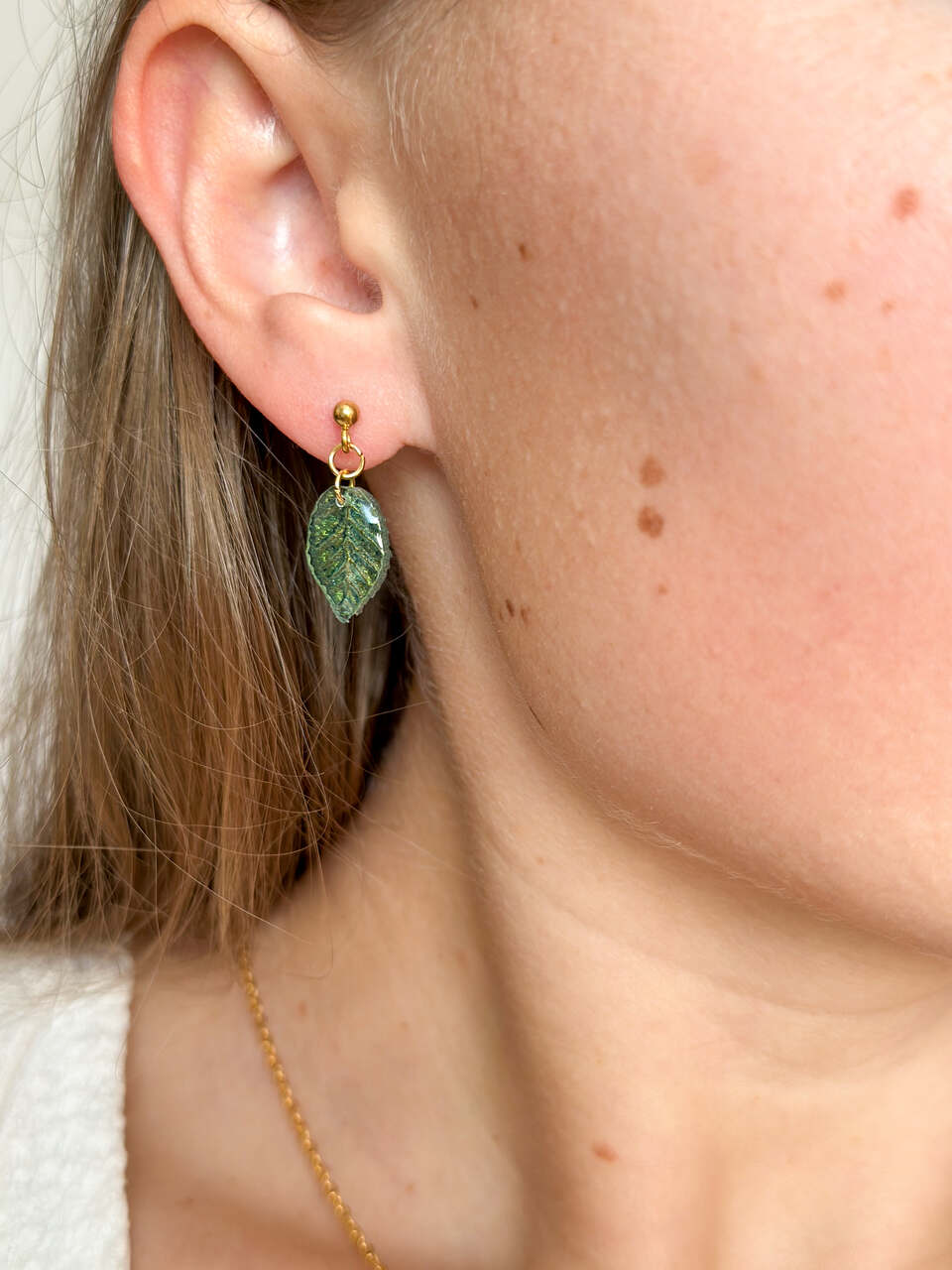 kolczyki zielone liście, ręcznie malowane kolczyki, biżuteria handmade, kolczyki z żywicy, artystyczna biżuteria, kolczyki liście, lekkie kolczyki, kolczyki złote, kolczyki na prezent, unikalna biżuteria, kolczyki dwustronne, kolczyki handmade, kolczyki inspirowane naturą, eleganckie kolczyki, kolczyki z żywicy epoksydowej