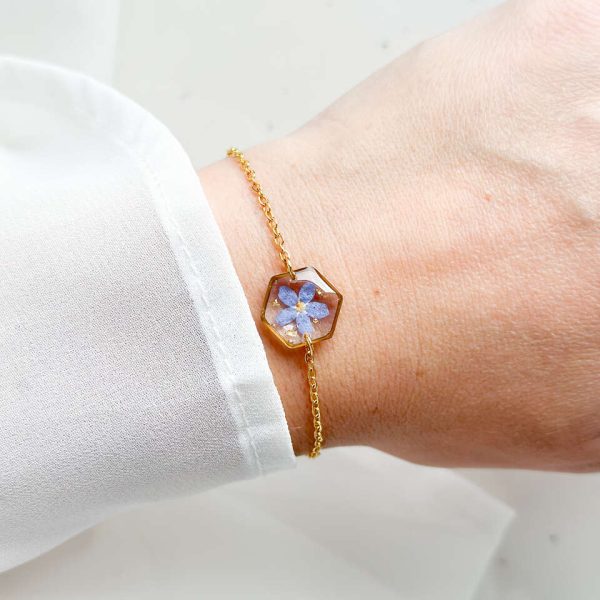 bransoletka z niezapominajką, bransoletka z sześcianem z żywicy, złota bransoletka z żywicy, biżuteria z kwiatami, bransoletka handmade, bransoletka z żywicy epoksydowej, delikatna bransoletka damska, naturalna biżuteria z kwiatów, bransoletka z niezapominajką w żywicy, prezent dla niej, biżuteria z niezapominajką