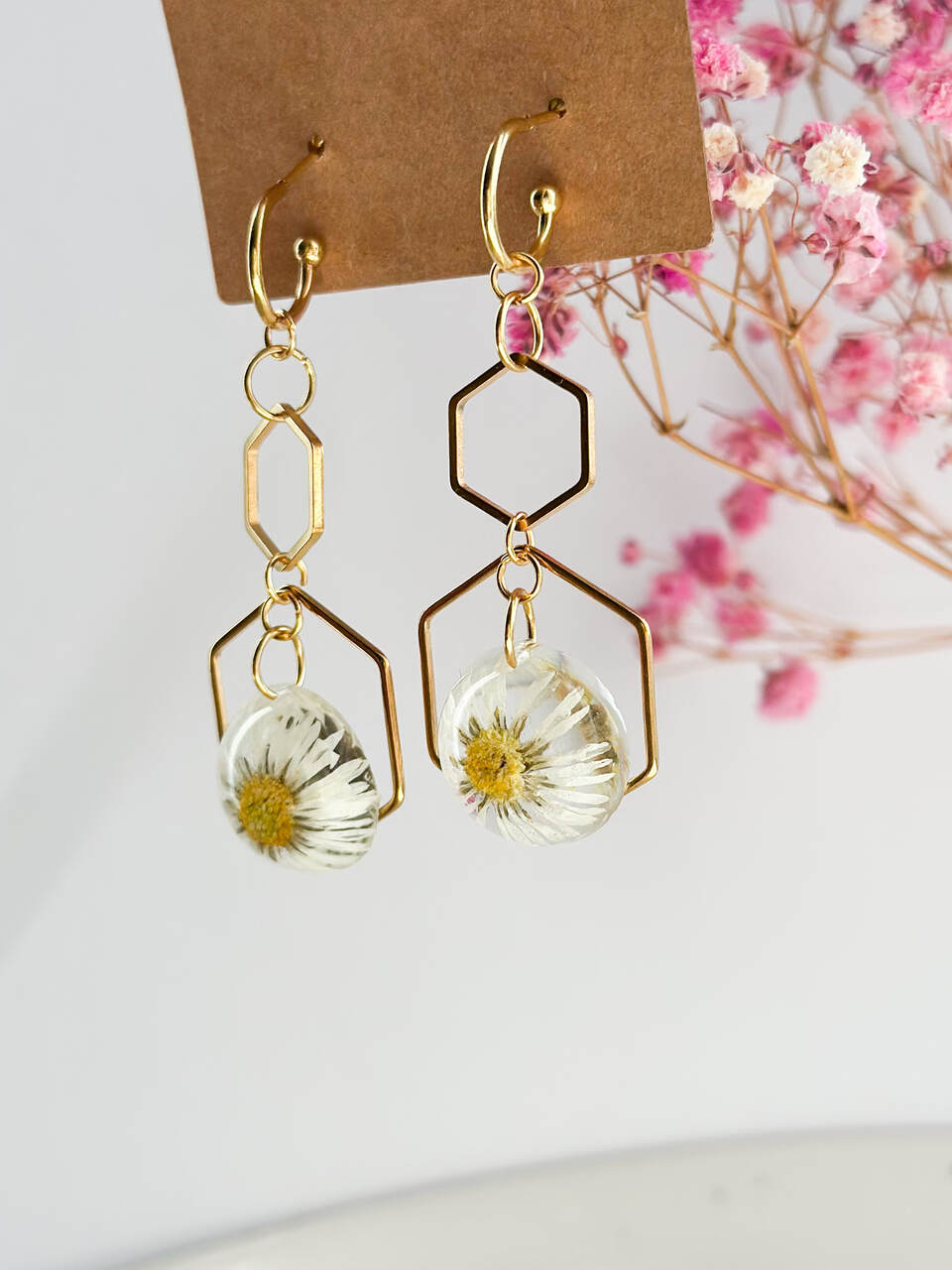 kolczyki wiszące, kolczyki z żywicy, kolczyki z prawdziwymi stokrotkami, biżuteria z żywicy, ręcznie robione kolczyki, kolczyki handmade, kolczyki z kwiatami, stokrotki w żywicy, kolczyki złote, kolczyki z sześcianem, kolczyki z kwiatem, biżuteria artystyczna, kolczyki eleganckie, kolczyki na prezent, biżuteria z natury, kolczyki ze stali chirurgicznej, złote kolczyki, delikatne kolczyki, kolczyki kobiece, kolczyki okrągłe, naturalna biżuteria, prezent dla niej, biżuteria handmade, żywica epoksydowa, kolczyki 5 cm