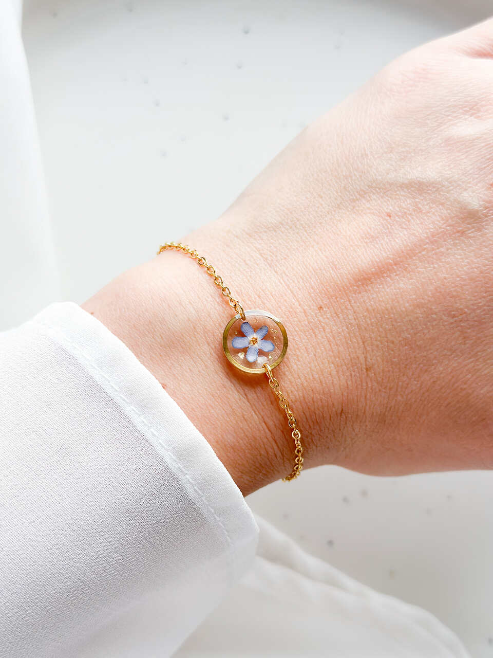 bransoletka z niezapominajką, złota bransoletka z żywicy, bransoletka z kwiatem w żywicy, biżuteria z niezapominajką, delikatna bransoletka handmade, naturalna biżuteria z kwiatów, bransoletka z żywicy epoksydowej, bransoletka z kwiatami, prezent dla niej, złota biżuteria z żywicy