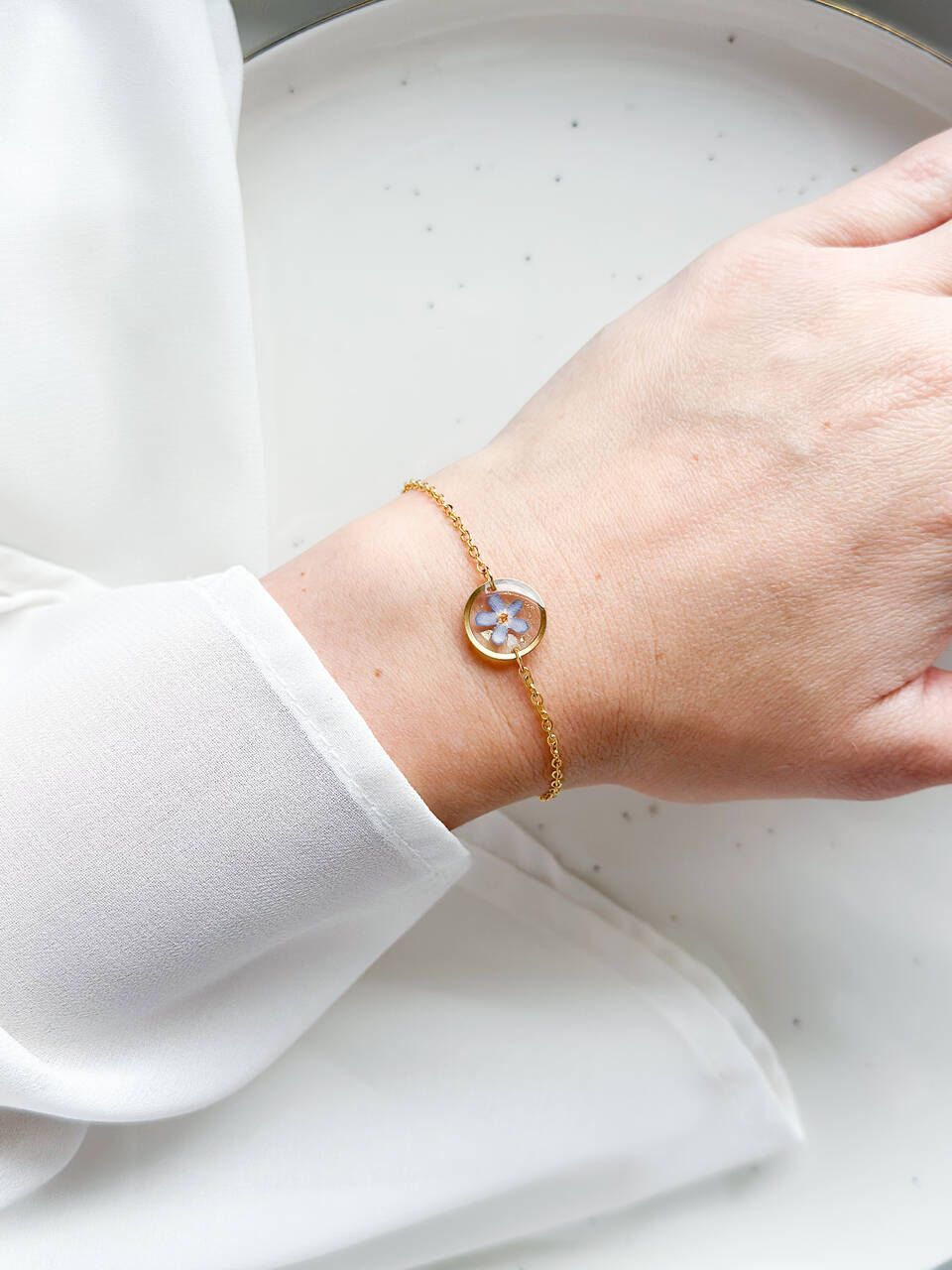 bransoletka z niezapominajką, złota bransoletka z żywicy, bransoletka z kwiatem w żywicy, biżuteria z niezapominajką, delikatna bransoletka handmade, naturalna biżuteria z kwiatów, bransoletka z żywicy epoksydowej, bransoletka z kwiatami, prezent dla niej, złota biżuteria z żywicy