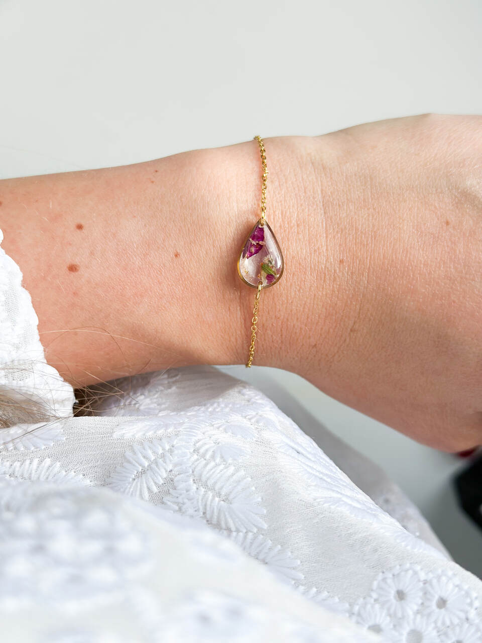 bransoletka z żywicy, bransoletka z kwiatami, złota bransoletka, bransoletka handmade, biżuteria z żywicy, biżuteria artystyczna, bransoletka z goździkiem, bransoletka z gipsówką, bransoletka łezka, biżuteria z natury, ręcznie robiona bransoletka, naturalna biżuteria, bransoletka regulowana, stal chirurgiczna złota, prezent dla niej, delikatna bransoletka, bransoletka romantyczna, biżuteria handmade, kwiaty w żywicy, elegancka biżuteria