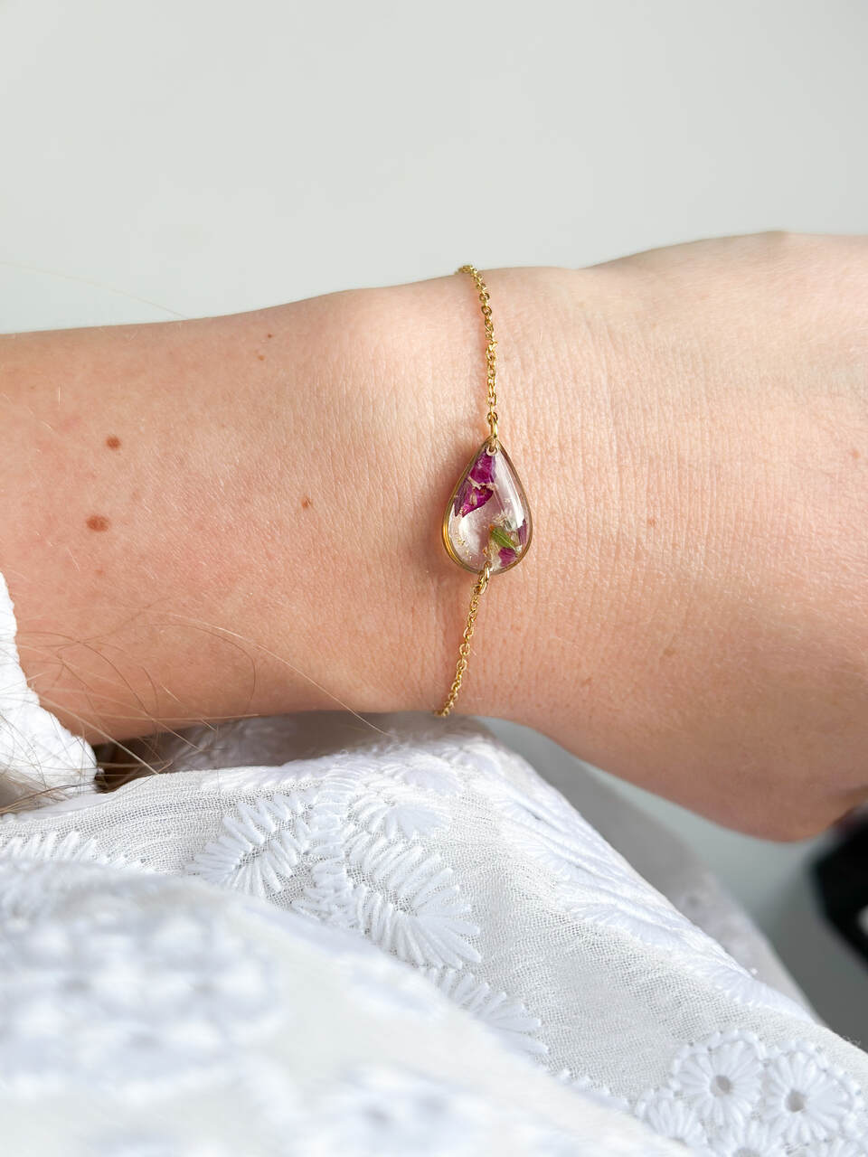 bransoletka z żywicy, bransoletka z kwiatami, złota bransoletka, bransoletka handmade, biżuteria z żywicy, biżuteria artystyczna, bransoletka z goździkiem, bransoletka z gipsówką, bransoletka łezka, biżuteria z natury, ręcznie robiona bransoletka, naturalna biżuteria, bransoletka regulowana, stal chirurgiczna złota, prezent dla niej, delikatna bransoletka, bransoletka romantyczna, biżuteria handmade, kwiaty w żywicy, elegancka biżuteria