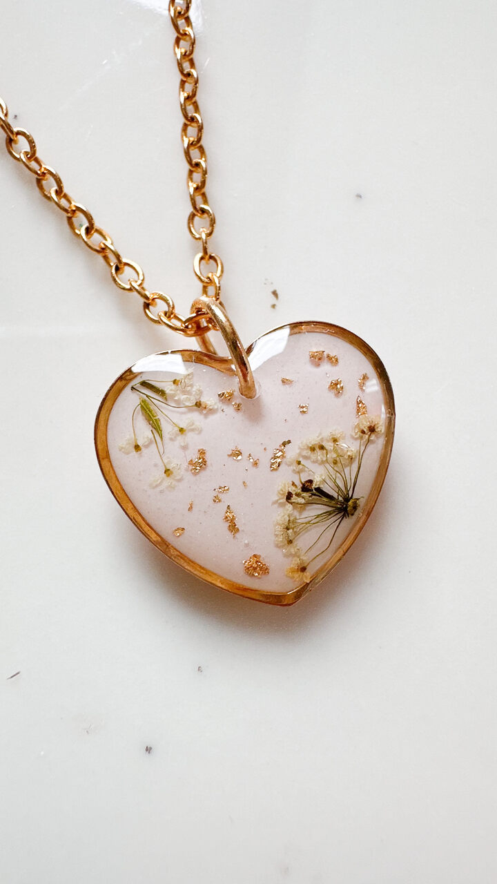 naszyjnik z prawdziwych kwiatów zalanych żywicą epoksydową, biżuteria z suszonymi kwiatami, ręcznie robiony naszyjnik z suszonych kwiatów, biżuteria z żywicy epoksydowej i suszonych kwiatów, biżuteria z kwiatami zalanymi żywicą, kwiaty w żywicy epoksydowej, pomysł na prezent, złoty naszyjnik z sercem, naszyjnik z brzoskwiniowym tłem, biżuteria handmade, naturalna biżuteria
