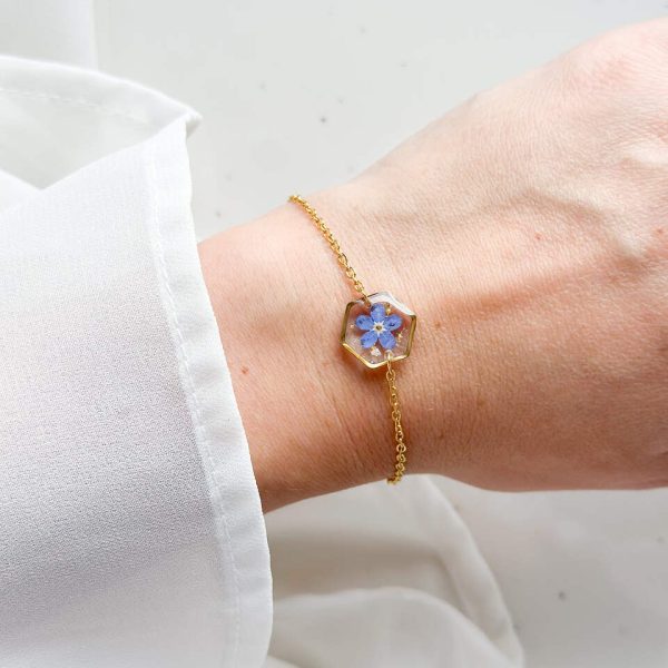 bransoletka z niezapominajką, bransoletka z sześcianem z żywicy, złota bransoletka z żywicy, biżuteria z kwiatami, bransoletka handmade, bransoletka z żywicy epoksydowej, delikatna bransoletka damska, naturalna biżuteria z kwiatów, bransoletka z niezapominajką w żywicy, prezent dla niej, biżuteria z niezapominajką