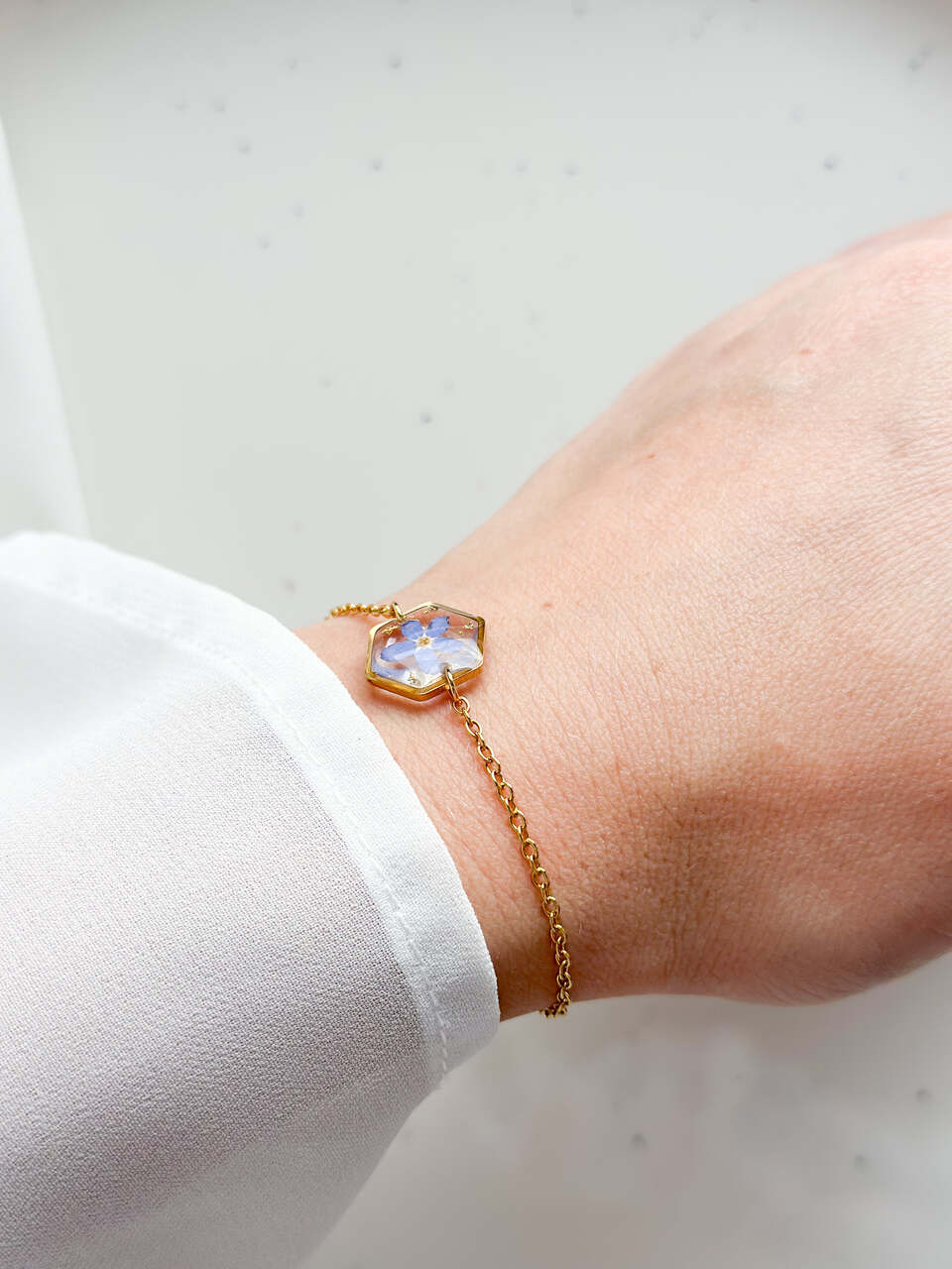 bransoletka z niezapominajką, bransoletka z sześcianem z żywicy, złota bransoletka z żywicy, biżuteria z kwiatami, bransoletka handmade, bransoletka z żywicy epoksydowej, delikatna bransoletka damska, naturalna biżuteria z kwiatów, bransoletka z niezapominajką w żywicy, prezent dla niej, biżuteria z niezapominajką