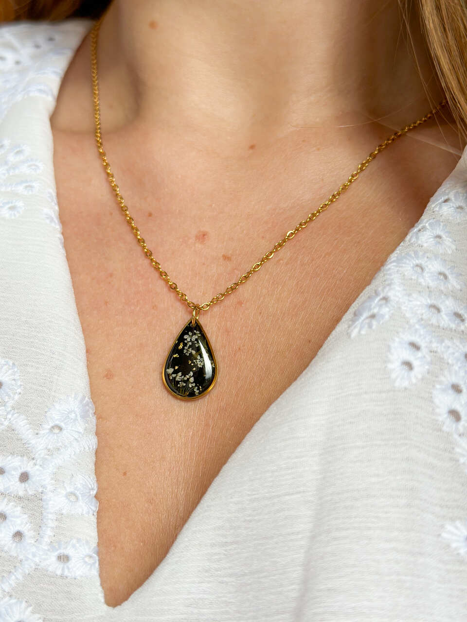 naszyjnik z prawdziwych kwiatów zalanych żywicą epoksydową, biżuteria z suszonymi kwiatami, ręcznie robiony naszyjnik z suszonych kwiatów, biżuteria z żywicy epoksydowej i suszonych kwiatów, biżuteria z kwiatami zalanymi żywicą, kwiaty w żywicy epoksydowej, pomysł na prezent, złoty naszyjnik łezka, naszyjnik z czarnym tłem, biżuteria handmade, naturalna biżuteria