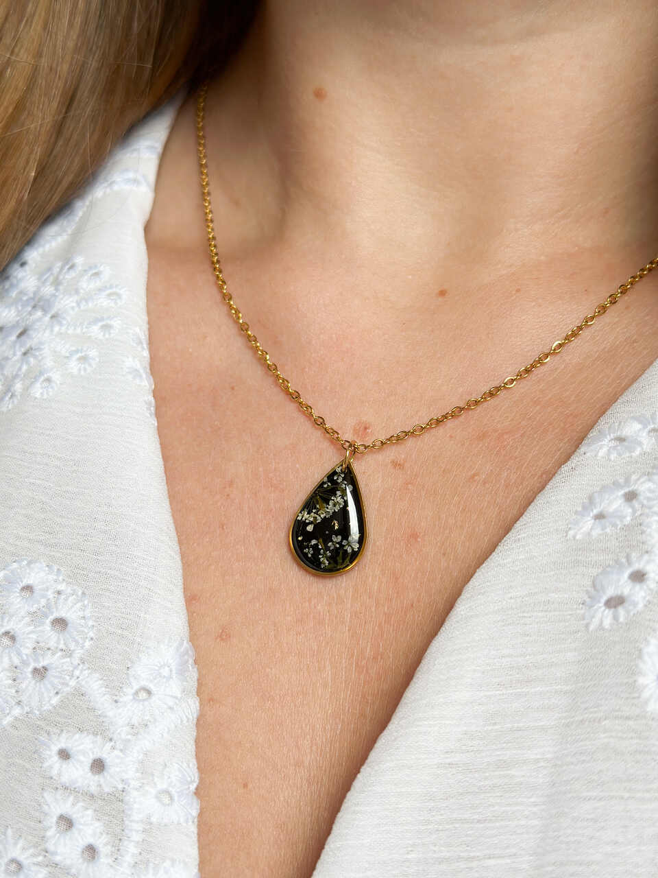 naszyjnik z prawdziwych kwiatów zalanych żywicą epoksydową, biżuteria z suszonymi kwiatami, ręcznie robiony naszyjnik z suszonych kwiatów, biżuteria z żywicy epoksydowej i suszonych kwiatów, biżuteria z kwiatami zalanymi żywicą, kwiaty w żywicy epoksydowej, pomysł na prezent, złoty naszyjnik łezka, naszyjnik z czarnym tłem, biżuteria handmade, naturalna biżuteria