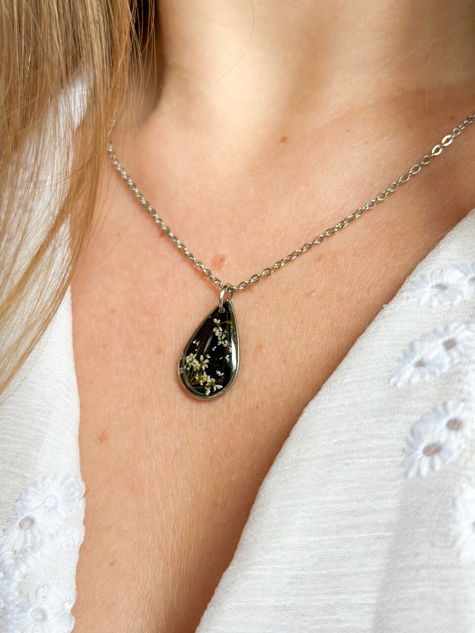 naszyjnik z prawdziwych kwiatów zalanych żywicą epoksydową, biżuteria z suszonymi kwiatami, ręcznie robiony naszyjnik z suszonych kwiatów, biżuteria z żywicy epoksydowej i suszonych kwiatów, biżuteria z kwiatami zalanymi żywicą, kwiaty w żywicy epoksydowej, pomysł na prezent, srebrny naszyjnik łezka, naszyjnik z czarnym tłem, biżuteria handmade, naturalna biżuteria