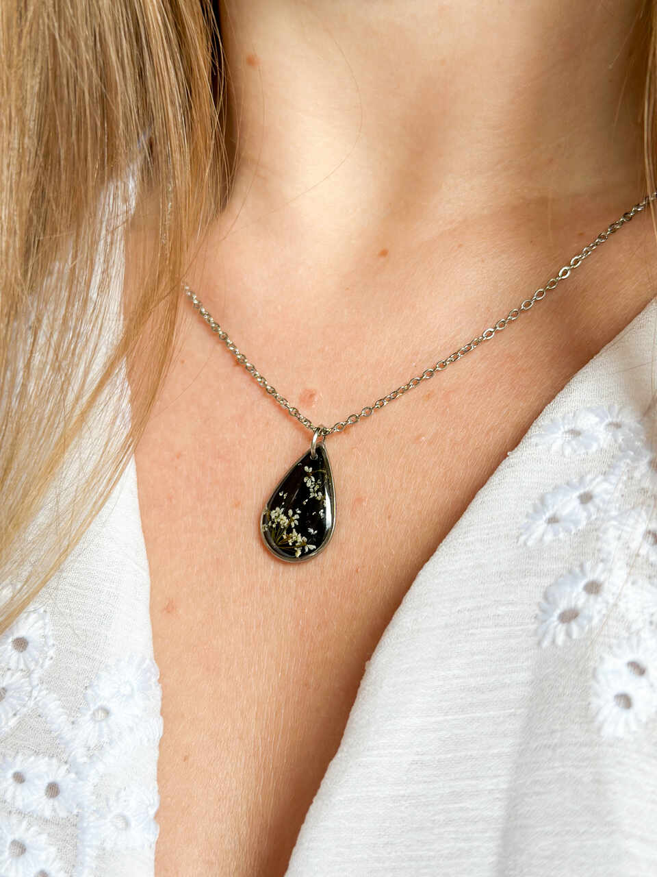 naszyjnik z prawdziwych kwiatów zalanych żywicą epoksydową, biżuteria z suszonymi kwiatami, ręcznie robiony naszyjnik z suszonych kwiatów, biżuteria z żywicy epoksydowej i suszonych kwiatów, biżuteria z kwiatami zalanymi żywicą, kwiaty w żywicy epoksydowej, pomysł na prezent, srebrny naszyjnik łezka, naszyjnik z czarnym tłem, biżuteria handmade, naturalna biżuteria