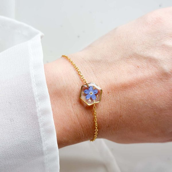 bransoletka z niezapominajką, bransoletka z sześcianem z żywicy, złota bransoletka z żywicy, biżuteria z kwiatami, bransoletka handmade, bransoletka z żywicy epoksydowej, delikatna bransoletka damska, naturalna biżuteria z kwiatów, bransoletka z niezapominajką w żywicy, prezent dla niej, biżuteria z niezapominajką