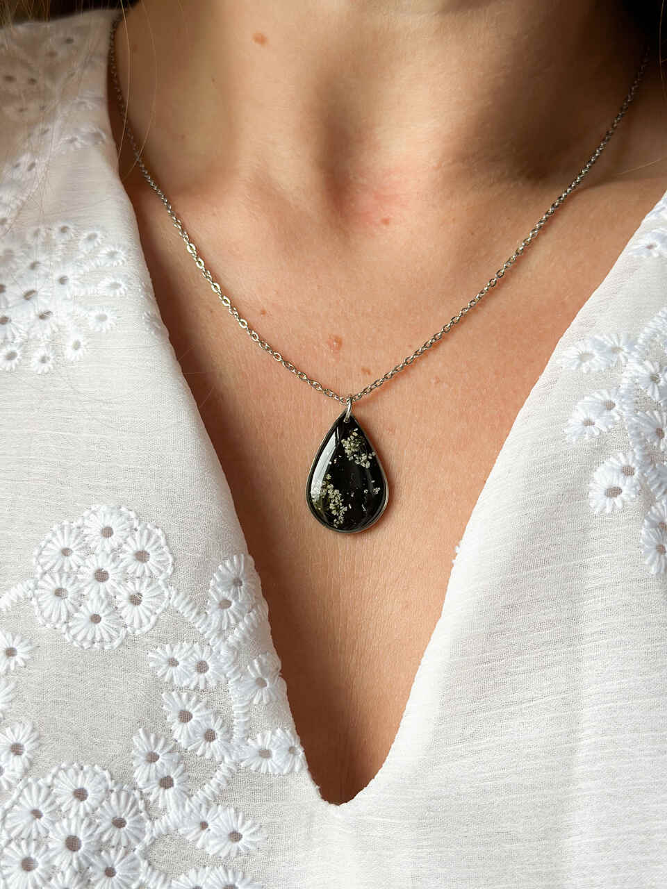 naszyjnik z prawdziwych kwiatów zalanych żywicą epoksydową, biżuteria z suszonymi kwiatami, ręcznie robiony naszyjnik z suszonych kwiatów, biżuteria z żywicy epoksydowej i suszonych kwiatów, biżuteria z kwiatami zalanymi żywicą, kwiaty w żywicy epoksydowej, pomysł na prezent, srebrny naszyjnik łezka, naszyjnik z czarnym tłem, biżuteria handmade, naturalna biżuteria