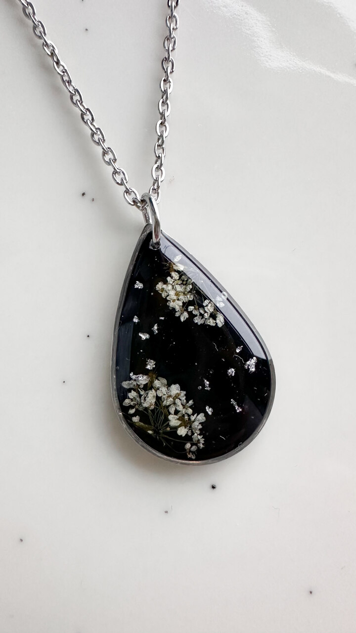 naszyjnik z prawdziwych kwiatów zalanych żywicą epoksydową, biżuteria z suszonymi kwiatami, ręcznie robiony naszyjnik z suszonych kwiatów, biżuteria z żywicy epoksydowej i suszonych kwiatów, biżuteria z kwiatami zalanymi żywicą, kwiaty w żywicy epoksydowej, pomysł na prezent, srebrny naszyjnik łezka, naszyjnik z czarnym tłem, biżuteria handmade, naturalna biżuteria