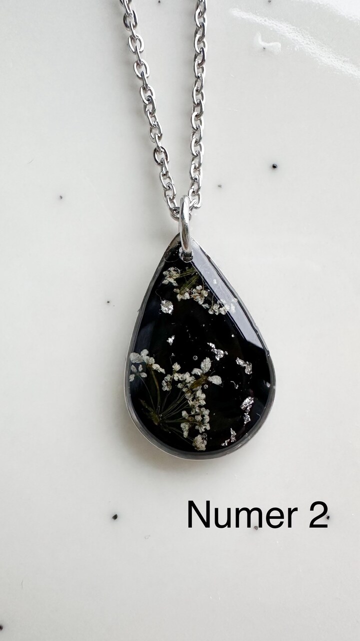 naszyjnik z prawdziwych kwiatów zalanych żywicą epoksydową, biżuteria z suszonymi kwiatami, ręcznie robiony naszyjnik z suszonych kwiatów, biżuteria z żywicy epoksydowej i suszonych kwiatów, biżuteria z kwiatami zalanymi żywicą, kwiaty w żywicy epoksydowej, pomysł na prezent, srebrny naszyjnik łezka, naszyjnik z czarnym tłem, biżuteria handmade, naturalna biżuteria