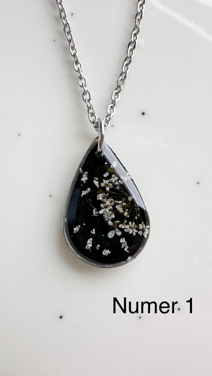 naszyjnik z prawdziwych kwiatów zalanych żywicą epoksydową, biżuteria z suszonymi kwiatami, ręcznie robiony naszyjnik z suszonych kwiatów, biżuteria z żywicy epoksydowej i suszonych kwiatów, biżuteria z kwiatami zalanymi żywicą, kwiaty w żywicy epoksydowej, pomysł na prezent, srebrny naszyjnik łezka, naszyjnik z czarnym tłem, biżuteria handmade, naturalna biżuteria