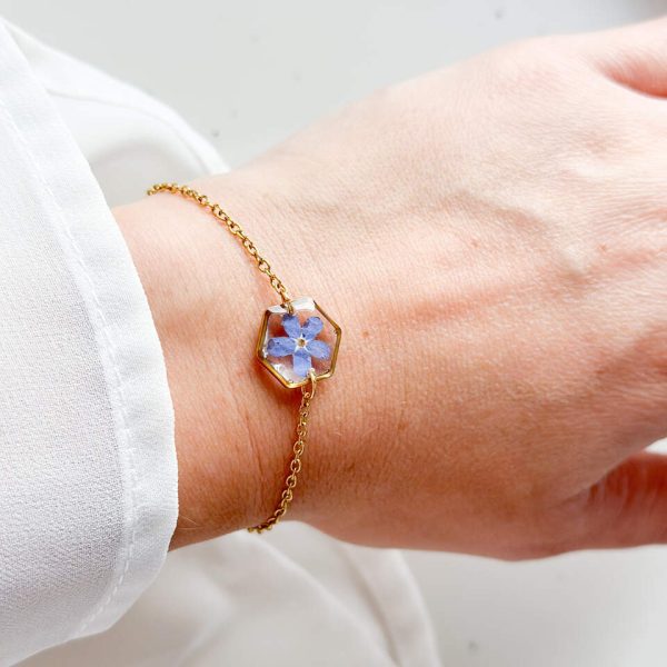 bransoletka z niezapominajką, bransoletka z sześcianem z żywicy, złota bransoletka z żywicy, biżuteria z kwiatami, bransoletka handmade, bransoletka z żywicy epoksydowej, delikatna bransoletka damska, naturalna biżuteria z kwiatów, bransoletka z niezapominajką w żywicy, prezent dla niej, biżuteria z niezapominajką