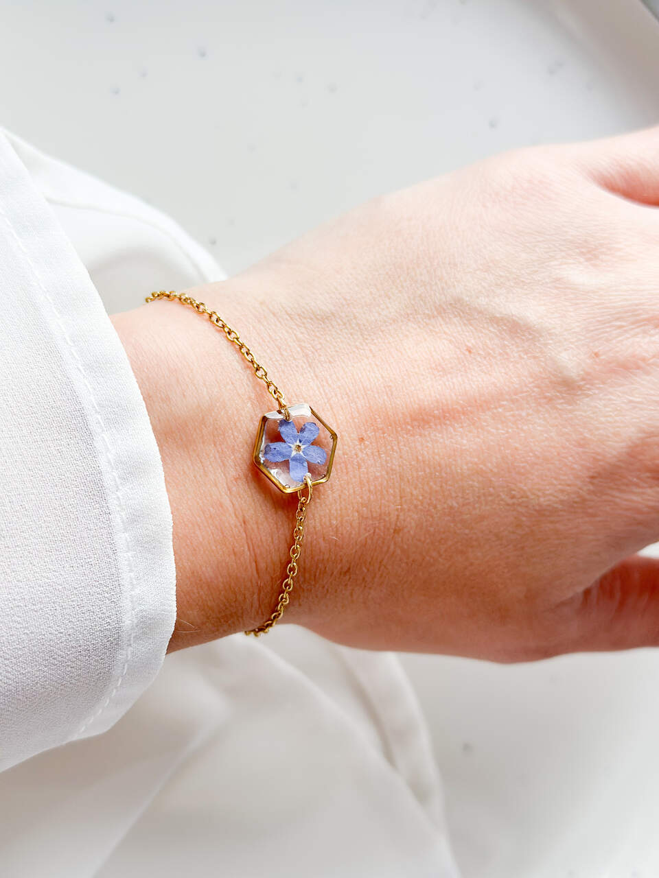 bransoletka z niezapominajką, bransoletka z sześcianem z żywicy, złota bransoletka z żywicy, biżuteria z kwiatami, bransoletka handmade, bransoletka z żywicy epoksydowej, delikatna bransoletka damska, naturalna biżuteria z kwiatów, bransoletka z niezapominajką w żywicy, prezent dla niej, biżuteria z niezapominajką