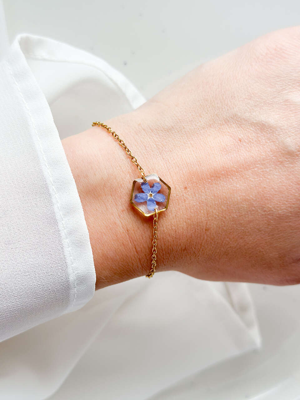 bransoletka z niezapominajką, bransoletka z sześcianem z żywicy, złota bransoletka z żywicy, biżuteria z kwiatami, bransoletka handmade, bransoletka z żywicy epoksydowej, delikatna bransoletka damska, naturalna biżuteria z kwiatów, bransoletka z niezapominajką w żywicy, prezent dla niej, biżuteria z niezapominajką