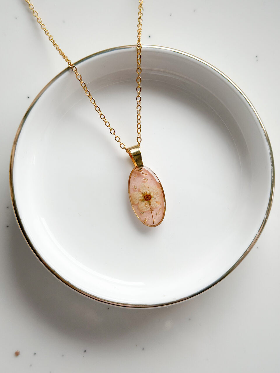 naszyjnik z kwiatów zalanych żywicą, biżuteria z prawdziwych kwiatów, biżuteria z suszonych kwiatów, ręcznie robiona biżuteria z żywicy, złoty naszyjnik elipsa, złoty medalion z kwiatem, biżuteria handmade, naszyjnik z żywicy z kwiatami, biżuteria artystyczna, biżuteria z natury, biżuteria z żywicy epoksydowej, delikatna biżuteria dla niej, oryginalny pomysł na prezent dla niej, unikalny prezent dla kobiety, naszyjnik z prawdziwymi kwiatami, biżuteria z żywicy handmade, kwiaty zatopione w żywicy, biżuteria dla miłośniczki natury