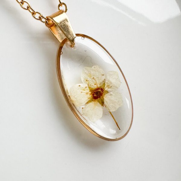 naszyjnik z kwiatów zalanych żywicą, biżuteria z prawdziwych kwiatów, ręcznie robiona biżuteria z żywicy, biżuteria z suszonych kwiatów, złoty naszyjnik elipsa, złoty medalion z kwiatem, nietypowy pomysł na prezent dla niej, biżuteria handmade, naszyjnik z żywicy z kwiatami, biżuteria artystyczna, biżuteria z natury, biżuteria z żywicy epoksydowej, delikatna biżuteria dla niej, unikalny prezent dla kobiety, naszyjnik z prawdziwymi kwiatami, biżuteria z żywicy handmade, kwiaty zatopione w żywicy, biżuteria dla miłośniczki natury