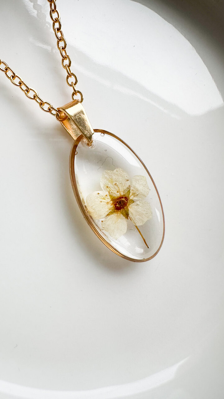 naszyjnik z kwiatów zalanych żywicą, biżuteria z prawdziwych kwiatów, ręcznie robiona biżuteria z żywicy, biżuteria z suszonych kwiatów, złoty naszyjnik elipsa, złoty medalion z kwiatem, nietypowy pomysł na prezent dla niej, biżuteria handmade, naszyjnik z żywicy z kwiatami, biżuteria artystyczna, biżuteria z natury, biżuteria z żywicy epoksydowej, delikatna biżuteria dla niej, unikalny prezent dla kobiety, naszyjnik z prawdziwymi kwiatami, biżuteria z żywicy handmade, kwiaty zatopione w żywicy, biżuteria dla miłośniczki natury
