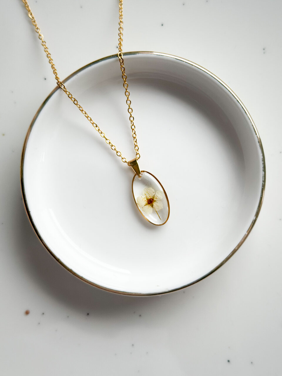 naszyjnik z kwiatów zalanych żywicą, biżuteria z prawdziwych kwiatów, ręcznie robiona biżuteria z żywicy, biżuteria z suszonych kwiatów, złoty naszyjnik elipsa, złoty medalion z kwiatem, nietypowy pomysł na prezent dla niej, biżuteria handmade, naszyjnik z żywicy z kwiatami, biżuteria artystyczna, biżuteria z natury, biżuteria z żywicy epoksydowej, delikatna biżuteria dla niej, unikalny prezent dla kobiety, naszyjnik z prawdziwymi kwiatami, biżuteria z żywicy handmade, kwiaty zatopione w żywicy, biżuteria dla miłośniczki natury