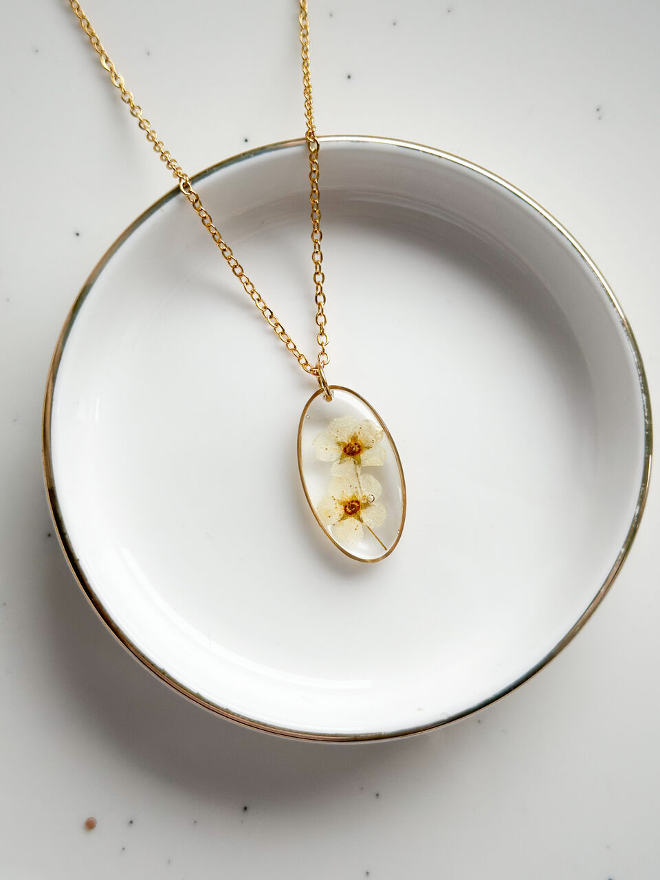 naszyjnik z kwiatów zalanych żywicą, biżuteria z prawdziwych kwiatów, ręcznie robiona biżuteria z żywicy, biżuteria z suszonych kwiatów, złoty naszyjnik elipsa, złoty medalion z kwiatem, nietypowy pomysł na prezent dla niej, biżuteria handmade, naszyjnik z żywicy z kwiatami, biżuteria artystyczna, biżuteria z natury, biżuteria z żywicy epoksydowej, delikatna biżuteria dla niej, unikalny prezent dla kobiety, naszyjnik z prawdziwymi kwiatami, biżuteria z żywicy handmade, kwiaty zatopione w żywicy, biżuteria dla miłośniczki natury