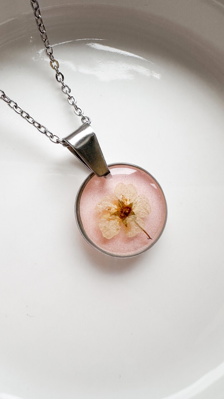 naszyjnik z kwiatów zalanych żywicą, biżuteria z prawdziwych kwiatów, biżuteria z żywicy epoksydowej, ręcznie robiona biżuteria z żywicy, naszyjnik z żywicy z kwiatami, biżuteria z suszonych kwiatów, nietypowy pomysł na prezent dla niej, biżuteria handmade, biżuteria z natury, prezent dla kobiety, unikalny prezent dla niej, naszyjnik z prawdziwymi kwiatami, naszyjnik pudrowy, naszyjnik różowy, biżuteria w kolorze pudrowym, biżuteria romantyczna, delikatna biżuteria dla niej, ręcznie robiony naszyjnik z żywicy, biżuteria artystyczna, prezent z duszą, kwiaty zatopione w żywicy, biżuteria dla miłośniczki natury