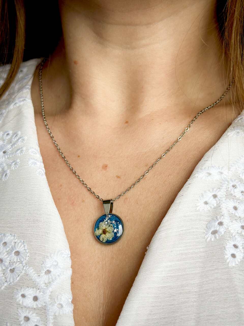 naszyjnik z kwiatów zalanych żywicą, biżuteria z prawdziwych kwiatów, biżuteria z żywicy epoksydowej, naszyjnik z żywicy z kwiatami, ręcznie robiona biżuteria z żywicy, biżuteria z suszonych kwiatów, nietypowy pomysł na prezent dla niej, biżuteria handmade, biżuteria z natury, prezent dla kobiety, unikalny prezent dla niej, naszyjnik z prawdziwymi kwiatami, naszyjnik z niebieskim tłem, naszyjnik szafirowy, biżuteria w kolorze kobaltowym, chabrowy naszyjnik z żywicy, delikatna biżuteria dla niej, ręcznie robiony naszyjnik z żywicy, biżuteria artystyczna, prezent z duszą, kwiaty zatopione w żywicy, biżuteria dla miłośniczki natury