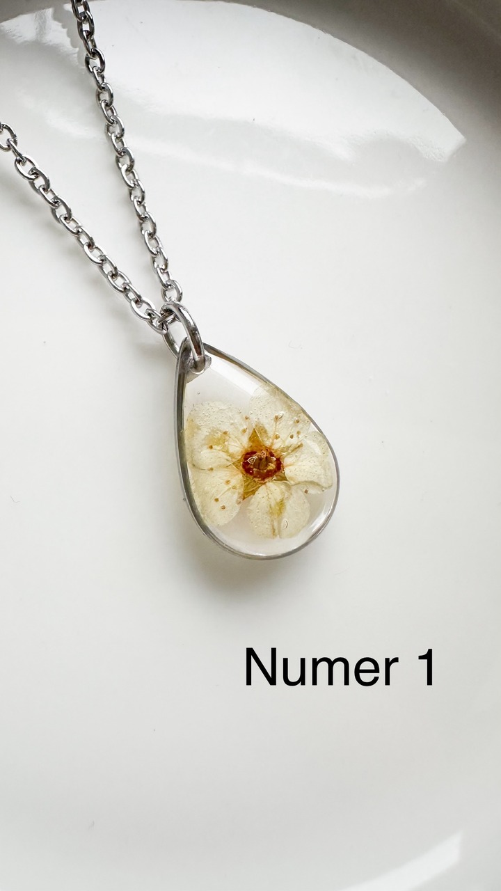 naszyjnik z kwiatów zalanych żywicą, biżuteria z prawdziwych kwiatów, biżuteria z żywicy epoksydowej, ręcznie robiona biżuteria z żywicy, naszyjnik z żywicy z kwiatami, biżuteria z suszonych kwiatów, nietypowy pomysł na prezent dla niej, biżuteria handmade, biżuteria z natury, prezent dla kobiety, unikalny prezent dla niej, naszyjnik z prawdziwymi kwiatami, naszyjnik przezroczysty, biżuteria minimalistyczna, naszyjnik łezka, biżuteria z duszą, biżuteria artystyczna, delikatna biżuteria dla niej, ręcznie robiony naszyjnik z żywicy, kwiaty zatopione w żywicy, biżuteria dla miłośniczki natury